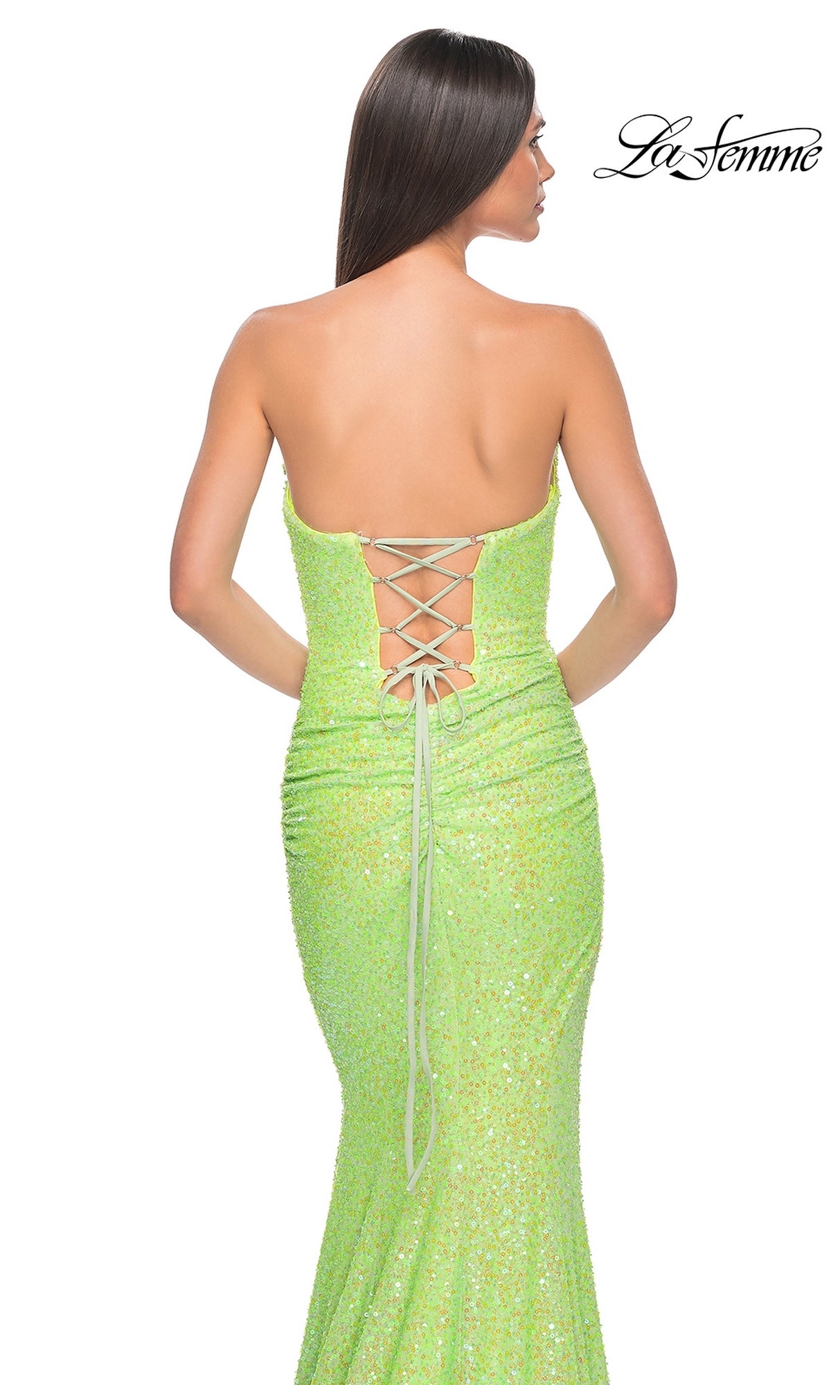 A woman stands with her back to the camera in the La Femme Strapless Long Sequin Prom Dress 39092—sparkly lime green, strapless, with a lace-up back. The La Femme logo appears in the top right corner.